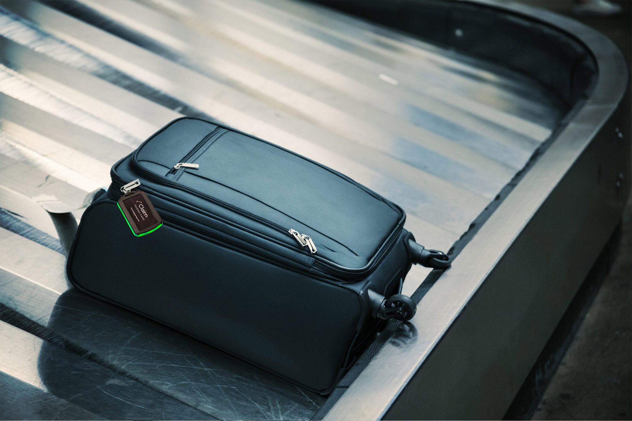 Black suitcase on airport baggage carousel.