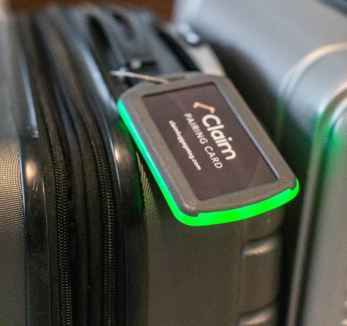 Luggage with glowing green tag on handle.